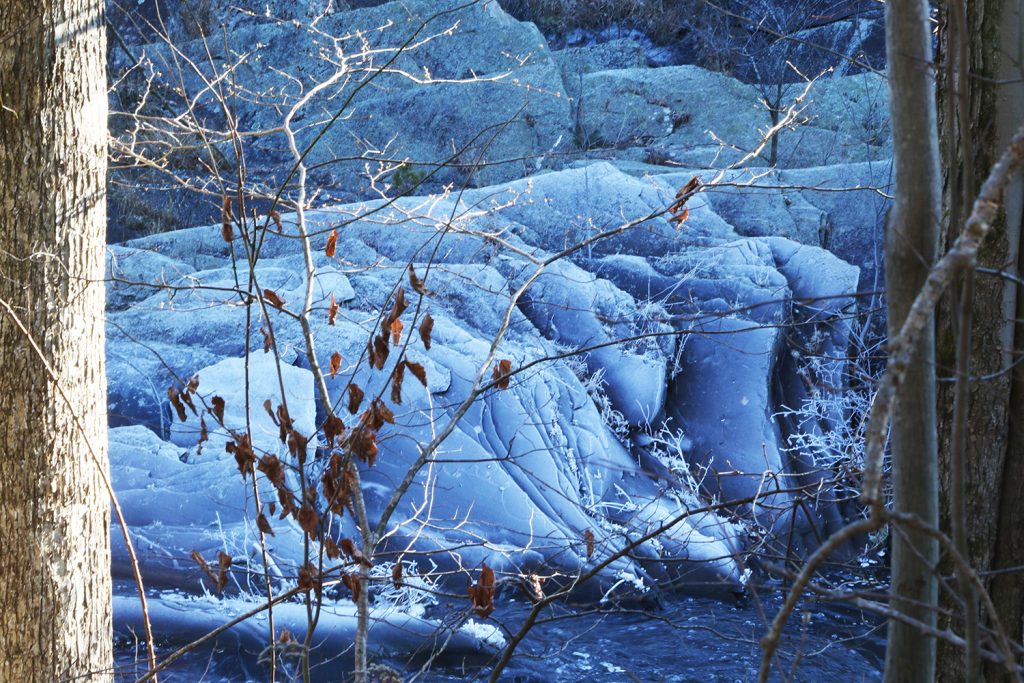 a blue-cast frozen waterfall in the catskill mountains
