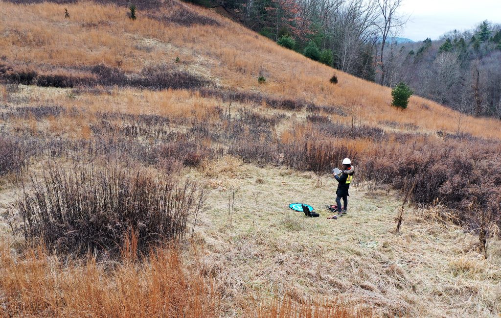 a female photographer in a winter field in the Catskill mountains of New York State