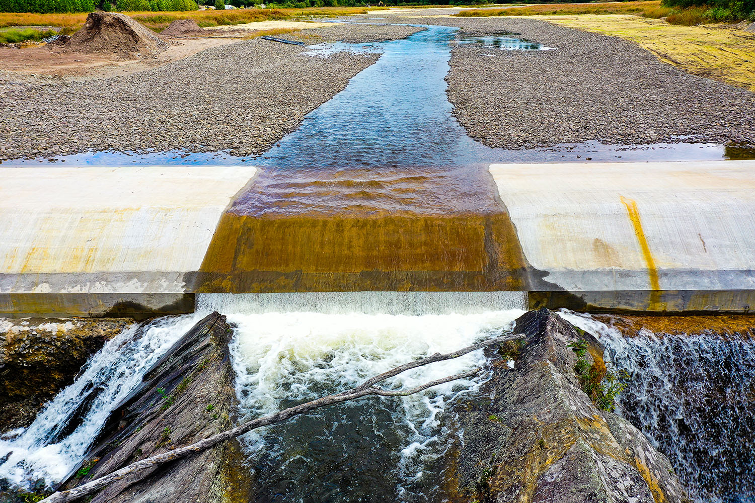 A dam with water from a riverbed, taken during progress photography stage