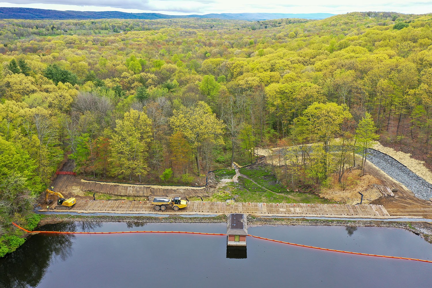 Aerial view of progress photography at a dam, showing construction along lake's edge.