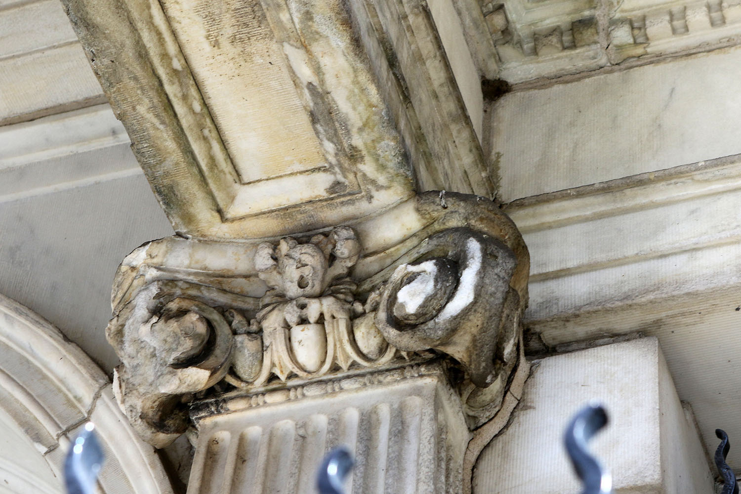 Eroded top of marble column under portico.